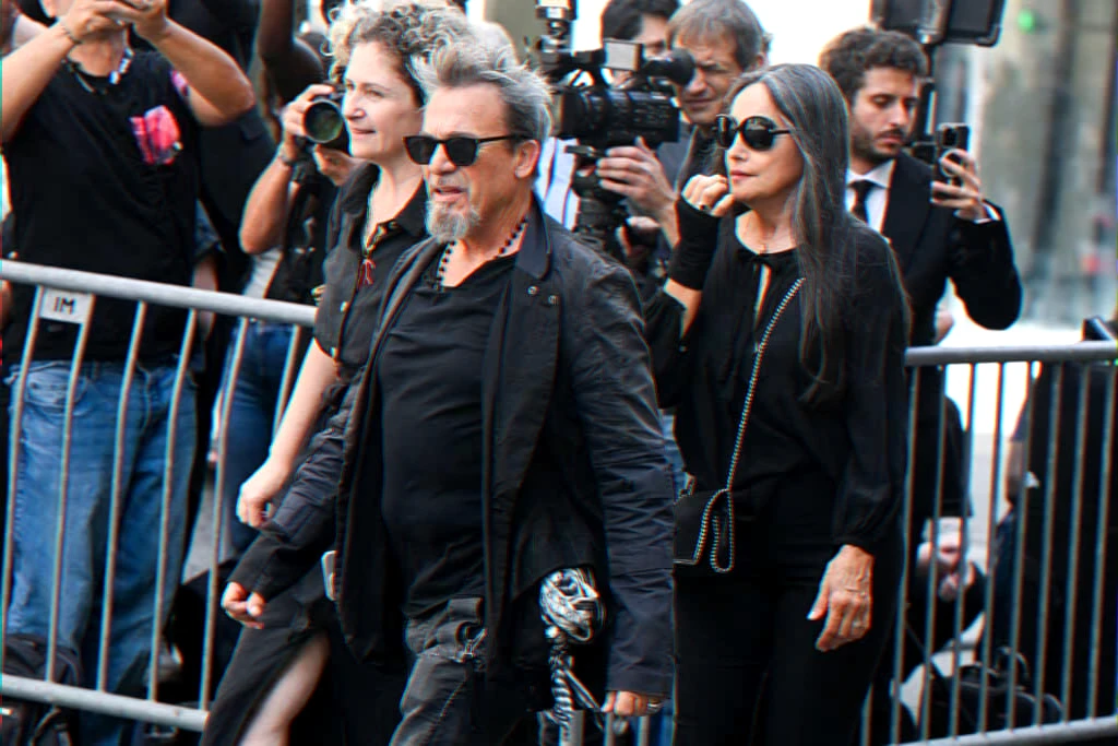 Couple arriving at a public event tied to a book testimony on a singer's cancer diagnosis