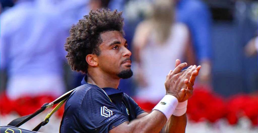 Sidelined player supporting teammates at Roland‑Garros
